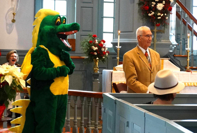 David Risseeuw delivers the story of St. George during the Dec. 29 service at St. George's Chapel, while the dragon (Jim Brand) hovers menacingly nearby.